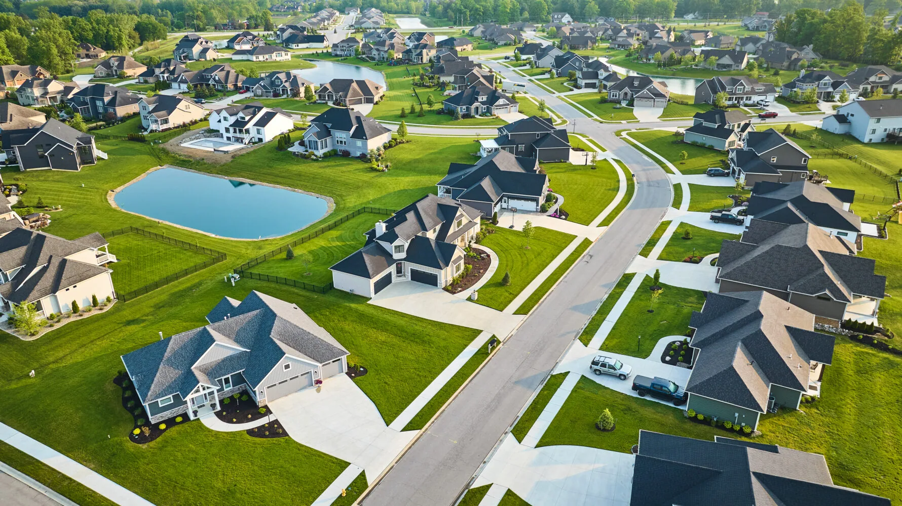 Rich expensive neighborhood aerial with mini mansions, high-end, million-dollar homes with ponds